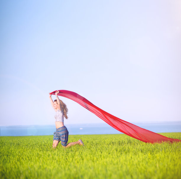 年轻快乐的女人在麦田里织着布。夏天的生活方式图片下载
