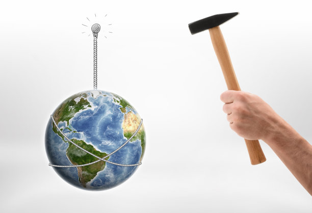 人类的手用地球把钉子钉进墙里图片下载