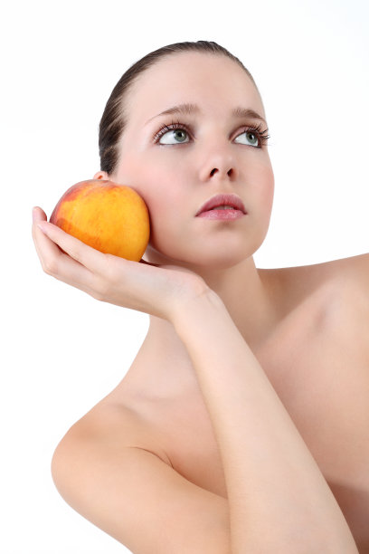 美丽的年轻女子与新鲜干净的皮肤和桃子图片下载