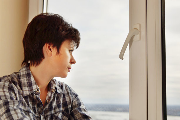 美丽的女人透过窗户望向室外图片下载