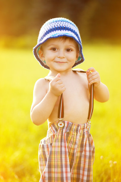 可爱的小男孩拿着他的吊带裤图片下载