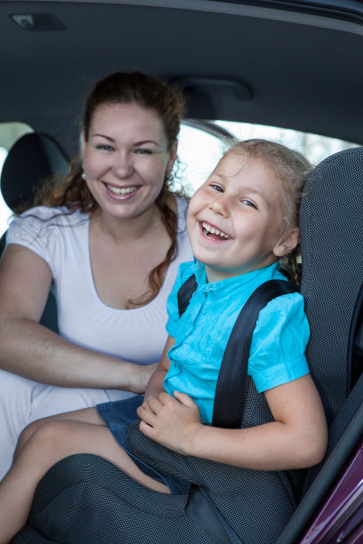 快乐的白人母亲和女儿坐在汽车安全座椅上图片下载