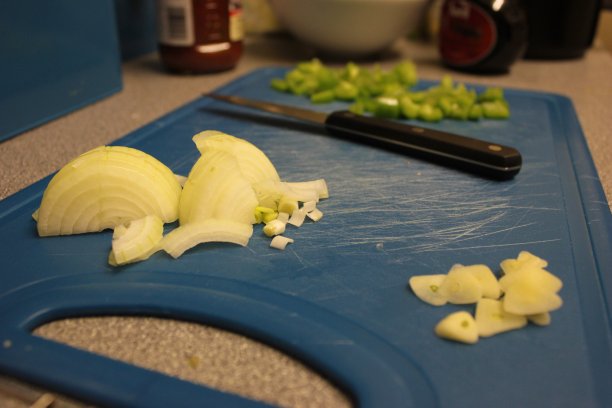 切碎的洋葱和胡椒放在蓝色的砧板上图片下载