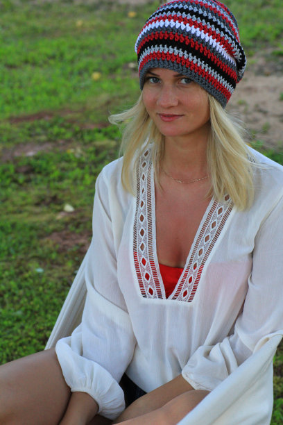 年轻的金发女子戴着夏装帽躺在吊床上图片下载