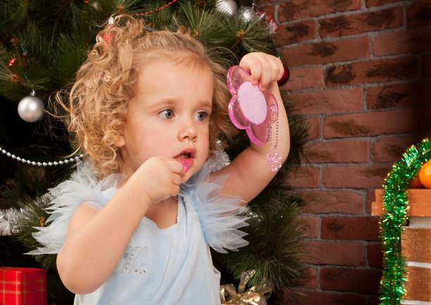 一个抹着口红戴着镜子的金发小女孩图片下载