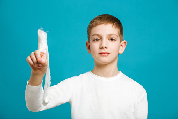 一个男孩的肖像，他的拇指上缠着医用绷带图片下载