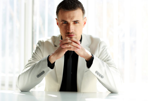 自信的商人坐在桌边图片下载