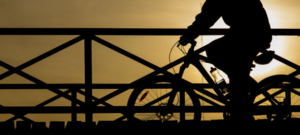 日落时一个骑自行车的人的剪影图片下载