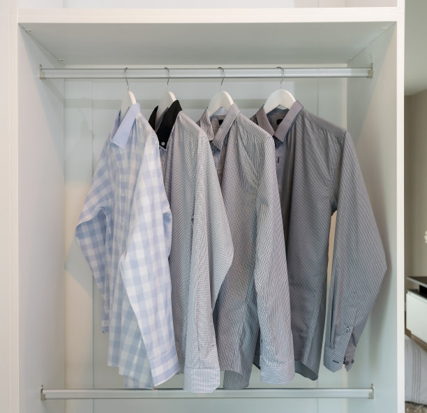 白色衣橱里挂在衣架上的一排衬衫图片下载
