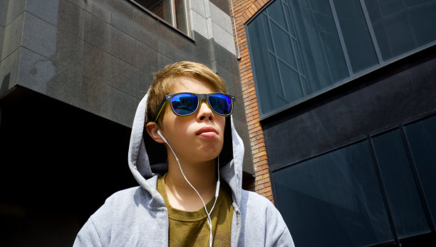 市民少年与镜子太阳镜和耳机困惑的建筑背景图片下载