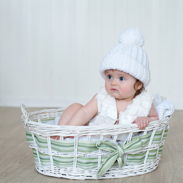 戴着白色针织绒球帽的新生女婴图片下载