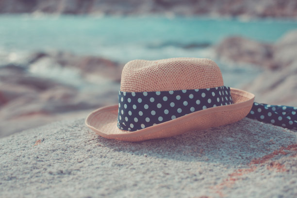 在海滩的岩石上戴太阳帽图片下载