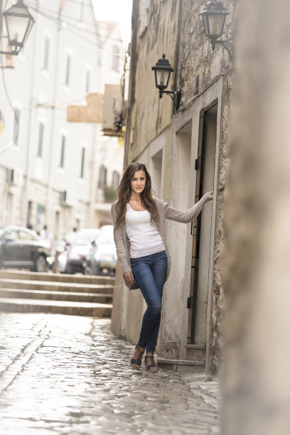 美丽的女孩在历史悠久的街道上摆姿势图片下载