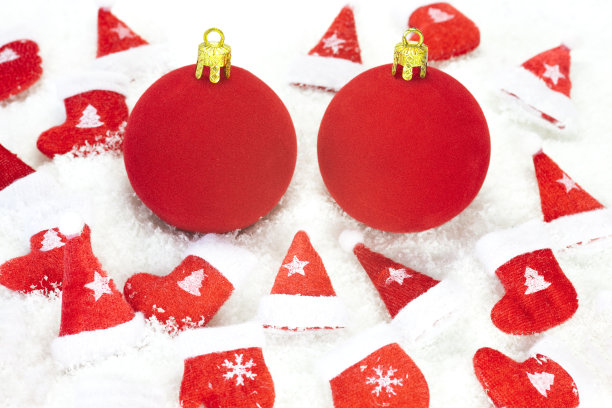 圣诞节装饰用两个红色的小玩意在雪地上图片下载
