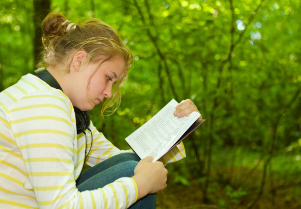 一个十几岁的女孩在外面看书图片下载