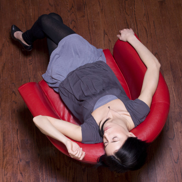 在红椅子上打盹的漂亮女人图片下载