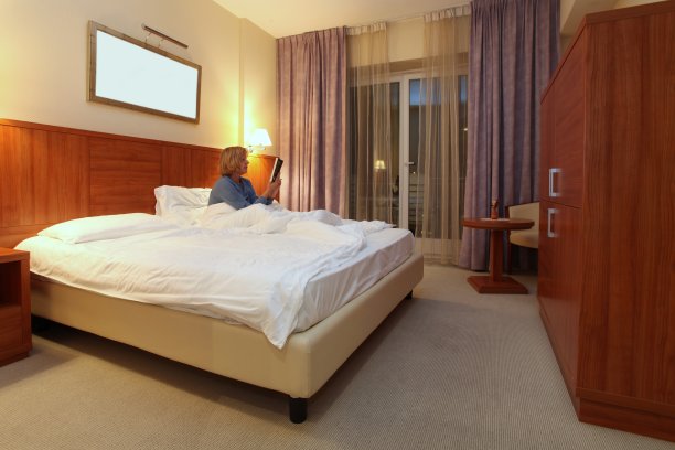 中年妇女在酒店房间的特大号床上休息图片下载