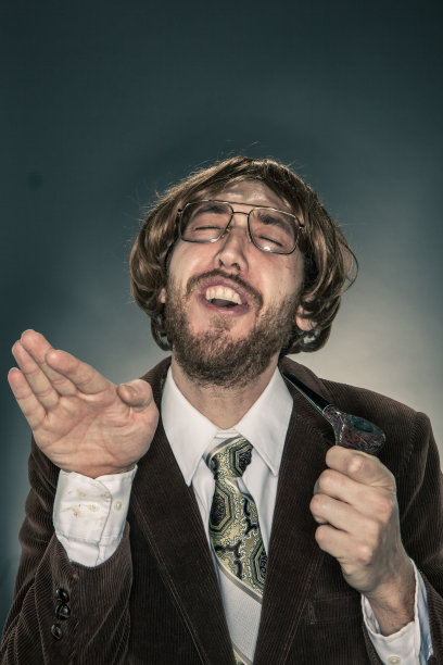 穿着灯芯绒夹克的书呆子学者的肖像，打着手势，闭着眼睛图片下载