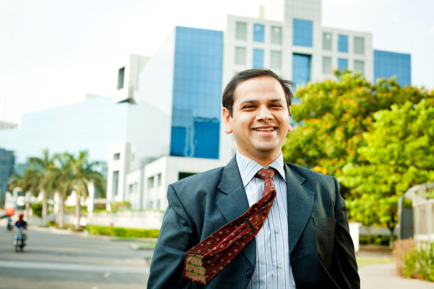 一位自信开朗的印度商人站在办公大楼前图片下载
