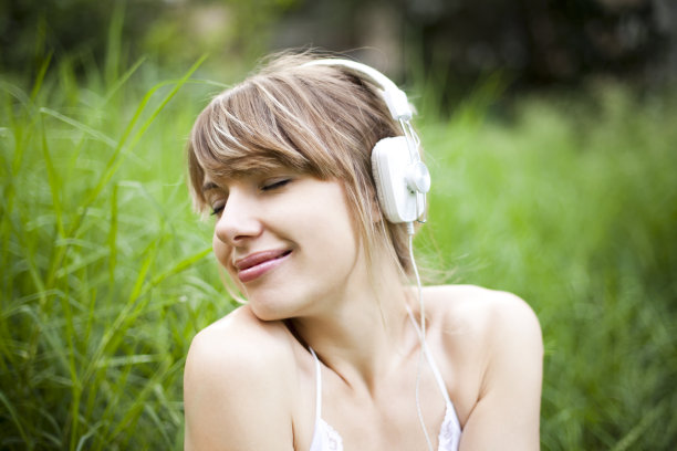 年轻美丽的女人在户外听音乐图片下载