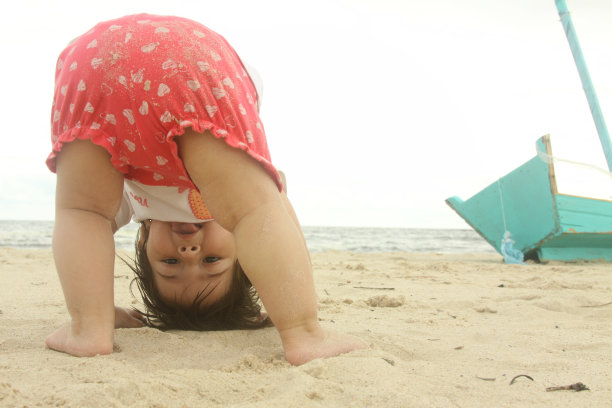 一年级宝宝在沙滩上玩海玩具船笑图片下载