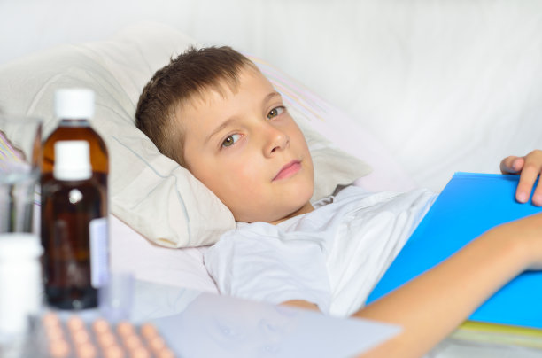 生病的男孩，书在床上图片下载