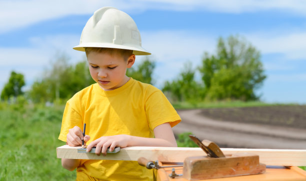 小木匠在量木材。图片下载