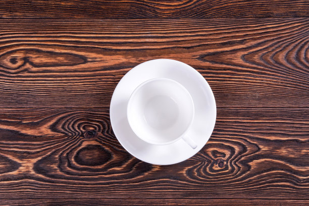 空白的白色杯子在旧的板子上。图片下载