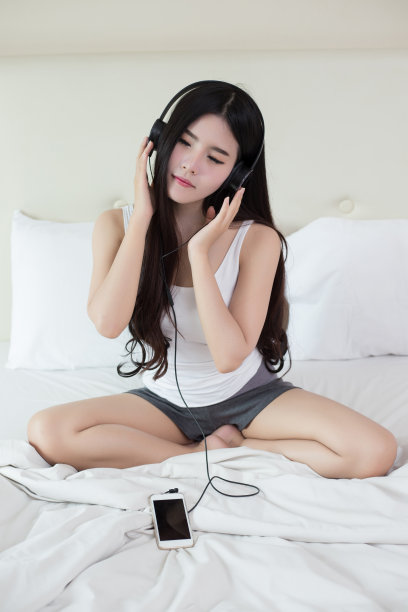 年轻女子戴着耳机听音乐图片下载