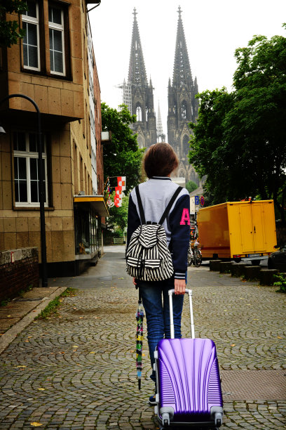在德国科隆街上拉着行李箱的女孩图片下载