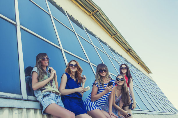 女人的女朋友戴着墨镜，手机在楼背上图片下载