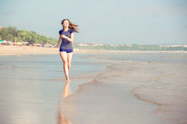 健康的女人在海滩上跑步，女孩在户外做运动图片下载