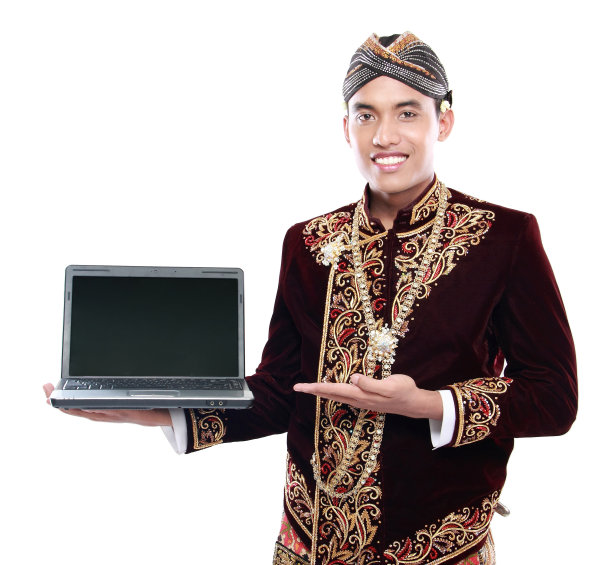 男子穿着传统的爪哇服装，拿着笔记本电脑图片下载