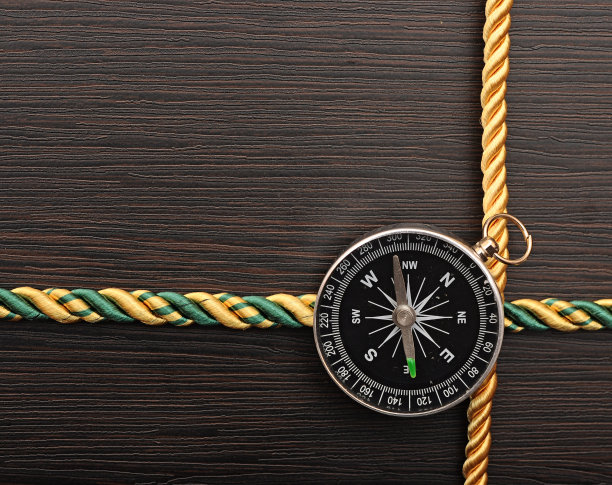 彩色绳架与指南针在木制背景图片下载