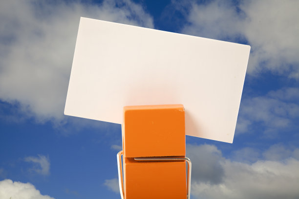 橙色衣服别针持有一个音符与多云的天空背景图片下载