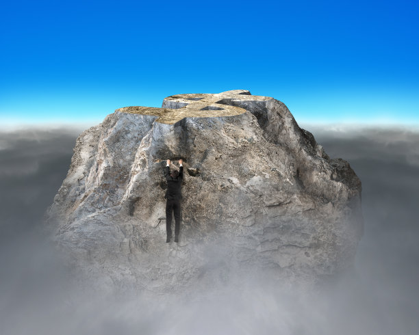 试图爬上金钱符号形状的岩石山图片下载