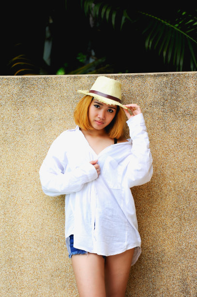 亚洲美丽的年轻性感的女人摆姿势附近的游泳池图片下载