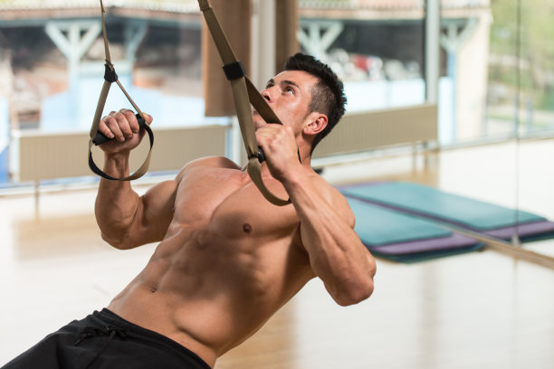 年轻有吸引力的男人训练与健身带图片下载