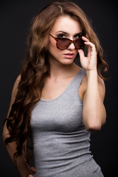 穿着灰色衬衫，背景是黑色的女孩纠正太阳镜图片下载