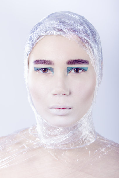 神秘的漂亮女人包在玻璃纸上向前看站图片下载