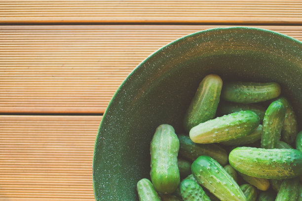 木桌上绿碗里的新鲜绿黄瓜图片下载
