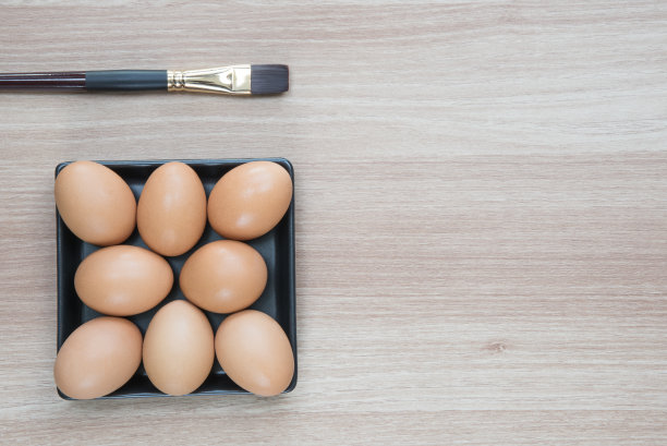 用刷子刷在黑色盘子里的八个鸡蛋图片下载