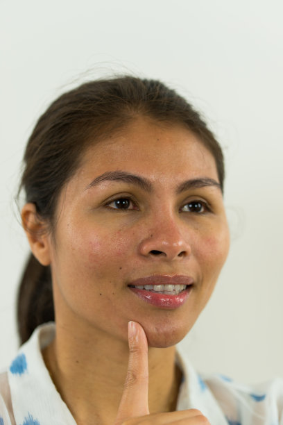 女人微笑着，手指放在下巴上图片下载