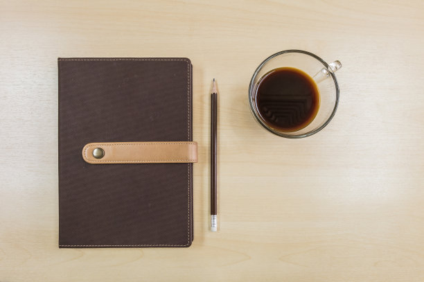 棕色笔记本，铅笔和黑咖啡的工作概念图片下载
