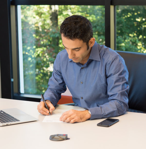 商人坐在桌子旁写在纸上图片下载