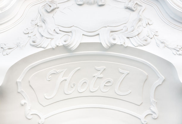 酒店的招牌挂在素净的白色墙上，墙上挂满了装饰品图片下载