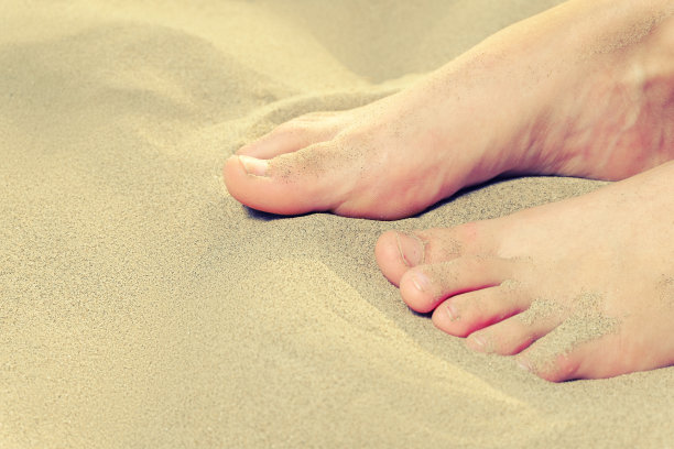 小女孩的脚踩在沙土上图片下载