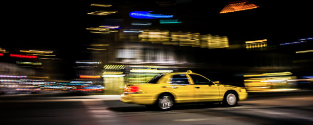 黄色出租车在天黑后穿越城市图片下载