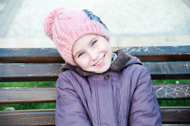 快乐的女学生坐在城市公园的长椅上图片下载