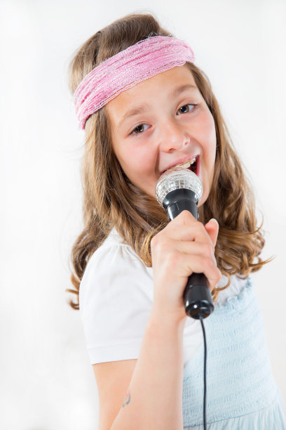 年轻女孩拿着麦克风唱歌图片下载